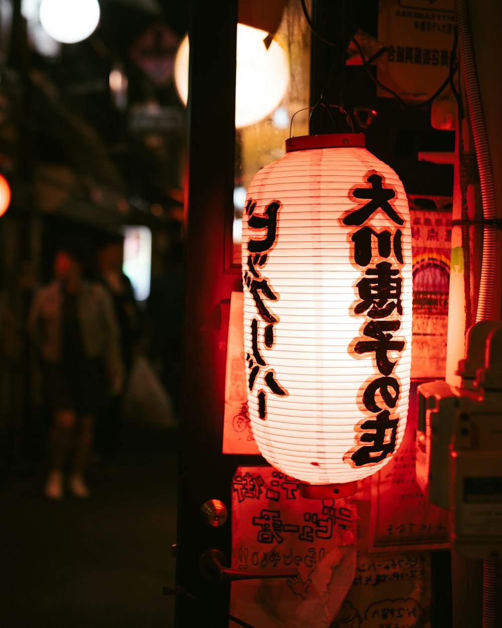 a lantern with asian writing on it hanging from a pole