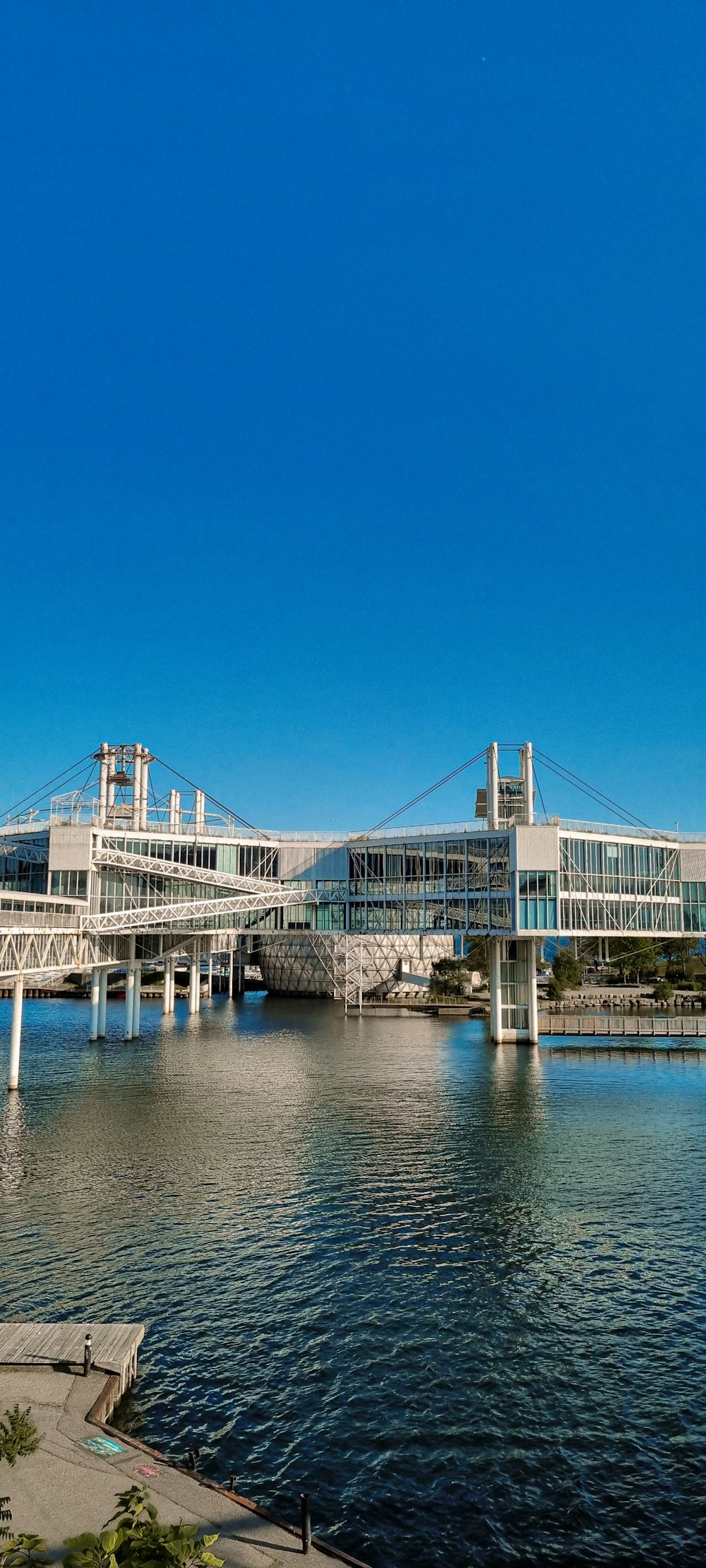 a bridge over a body of water with a building in the background