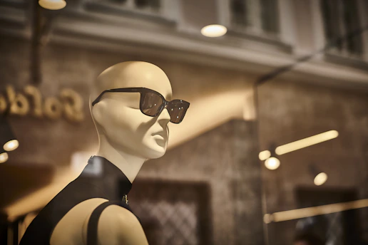 a mannequin wearing sunglasses in a store window