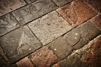 Various stone tiles displayed on a wooden surface showcasing texture and color variations