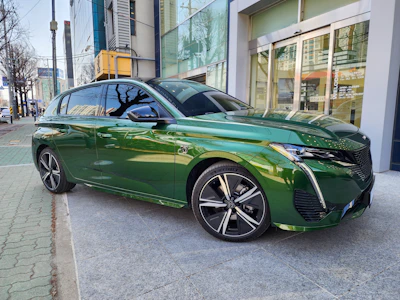 Sleek semi-new car parked in an urban setting with green accents reflecting the Distrito Verde brand colors