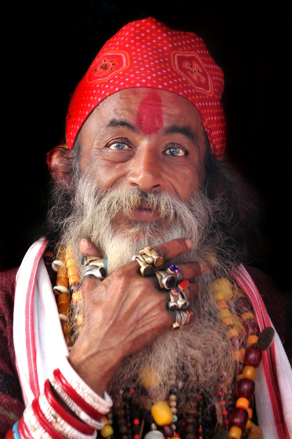 a man with a long beard wearing a red turban