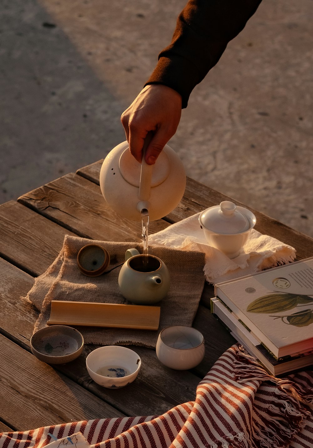 a person pouring water into a tea pot