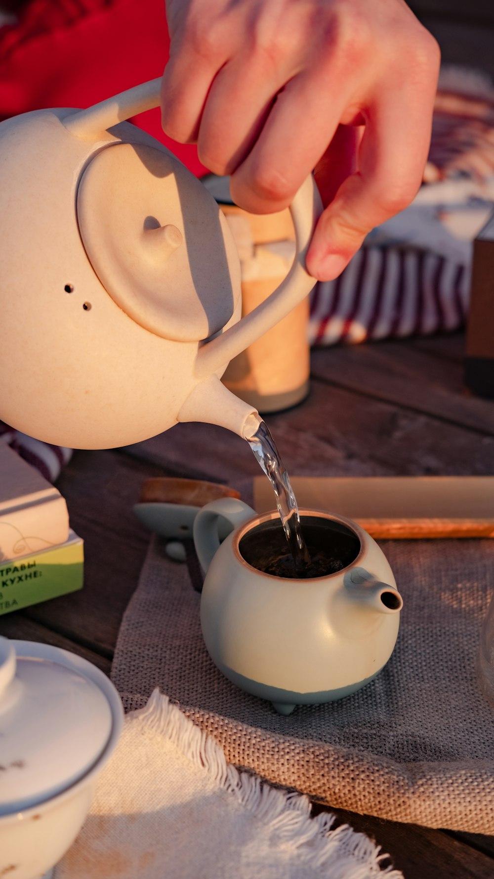 a person pours a cup of coffee into a teapot