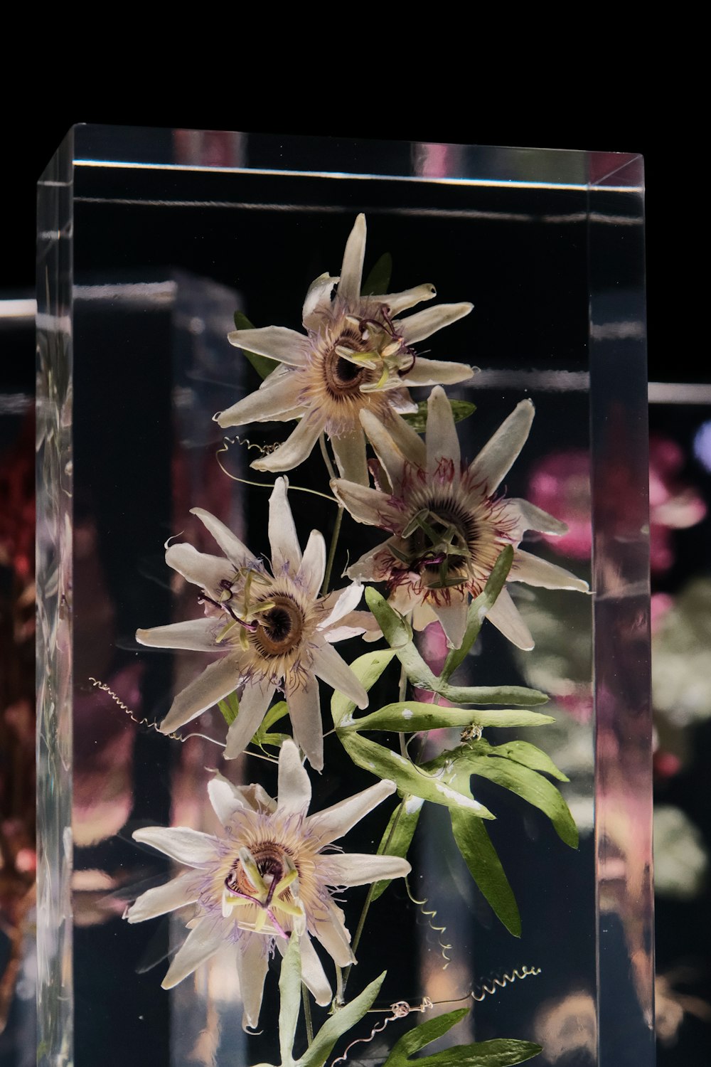 a clear vase filled with flowers on top of a table