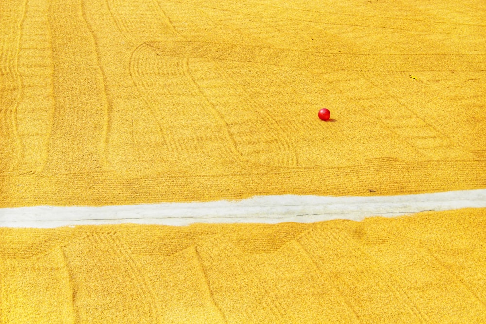 a red object sitting in the middle of a yellow field