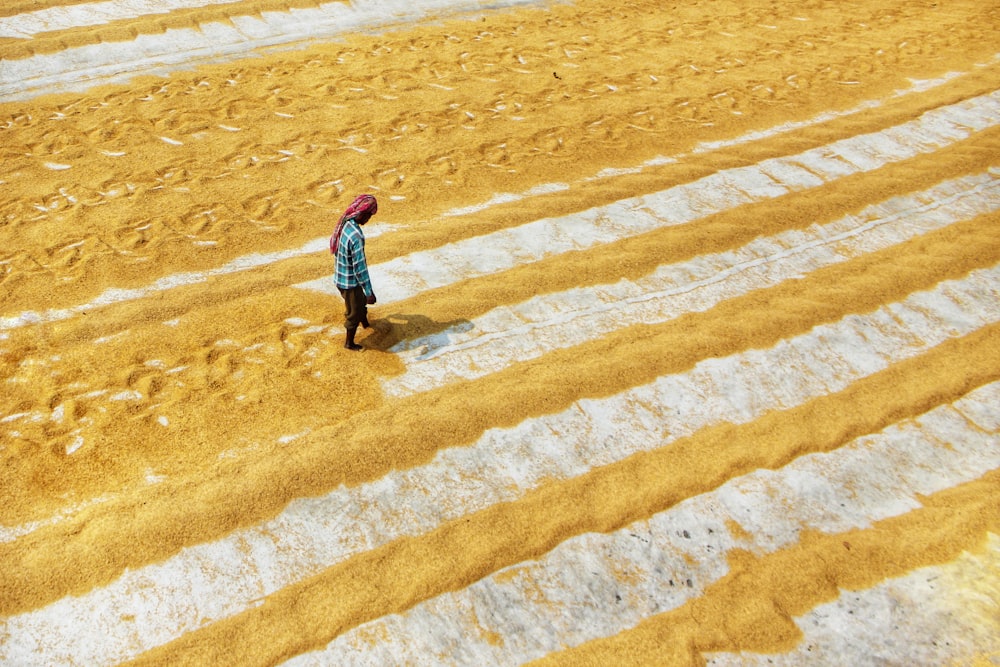 a person walking across a field covered in dirt