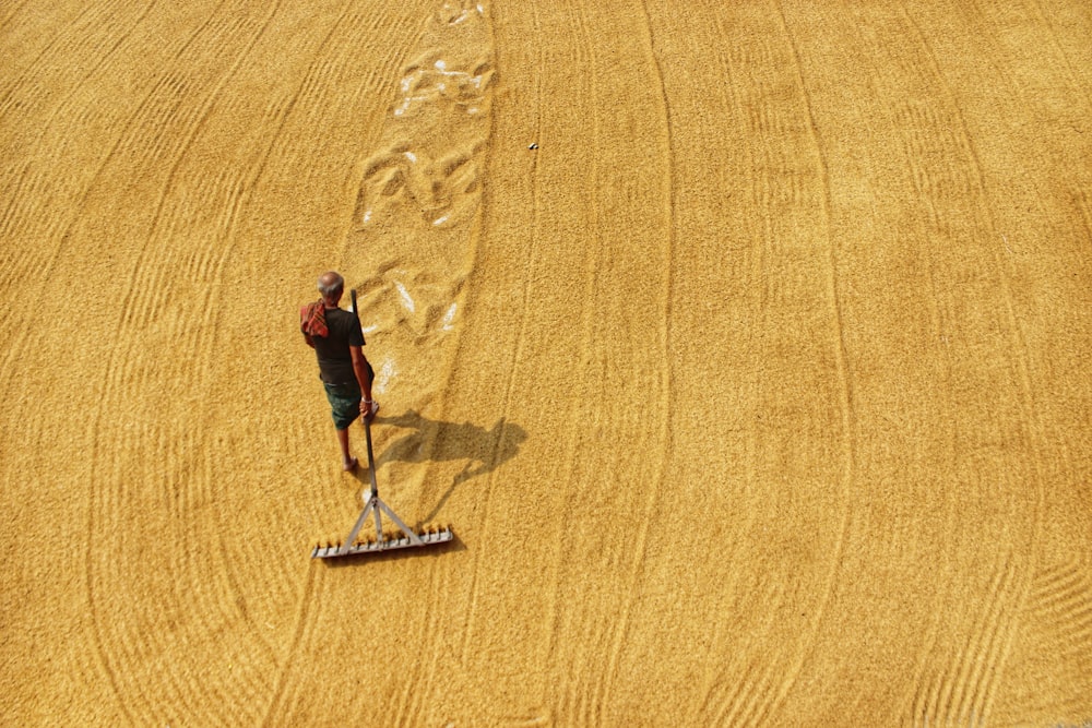 a person walking across a field with a broom