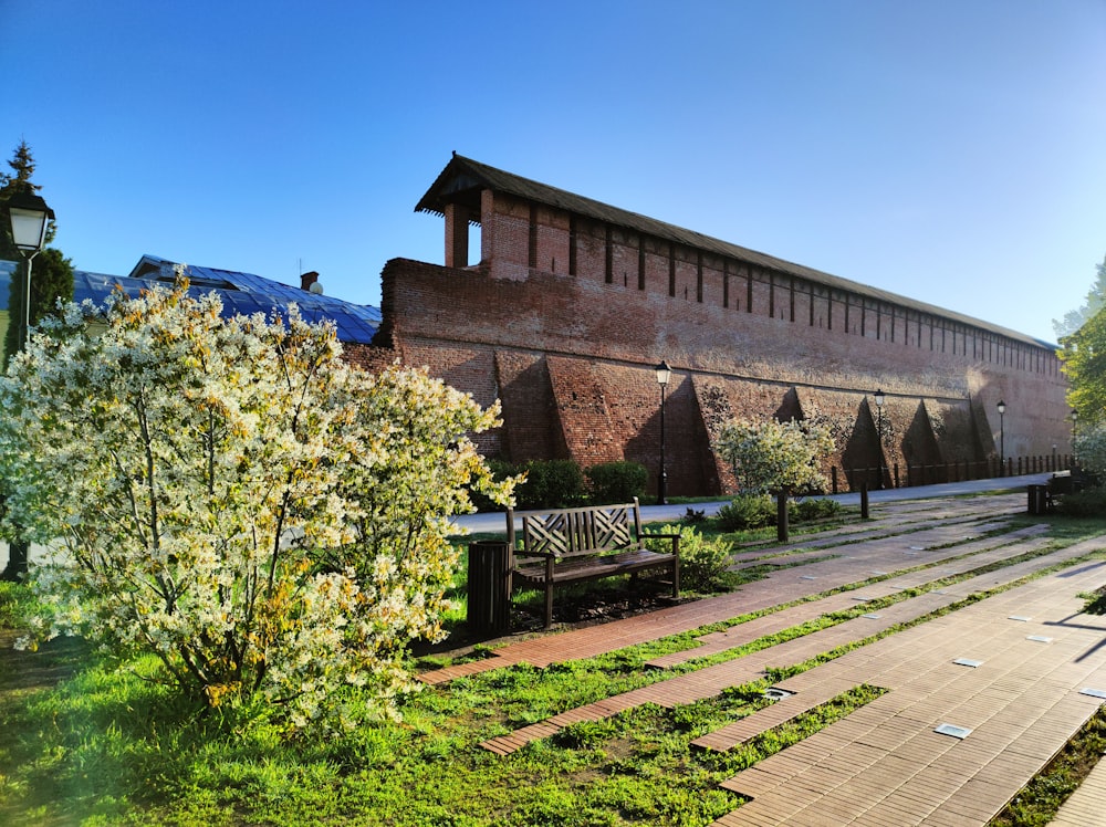 a brick building with a wooden bench in front of it