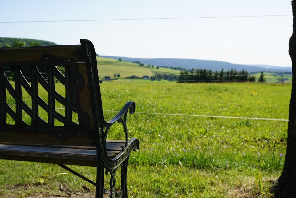 a wooden bench sitting in the middle of a field