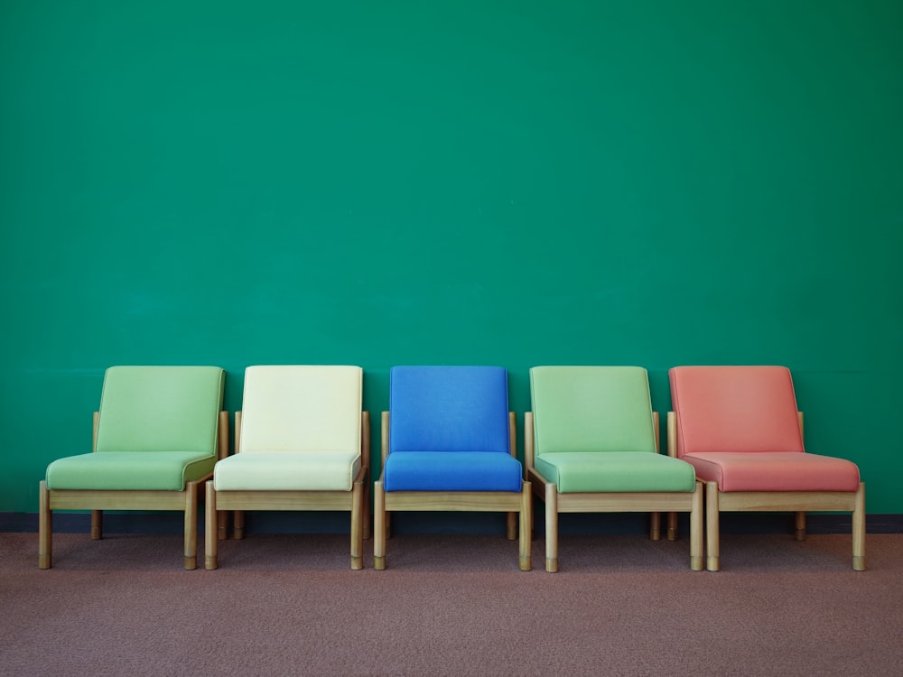 Une rangée de chaises colorées contre un mur végétal photo – Photo Chaise  Gratuite sur Unsplash