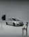 A sleek, minimalist studio setup with soft lighting highlighting a luxury car.