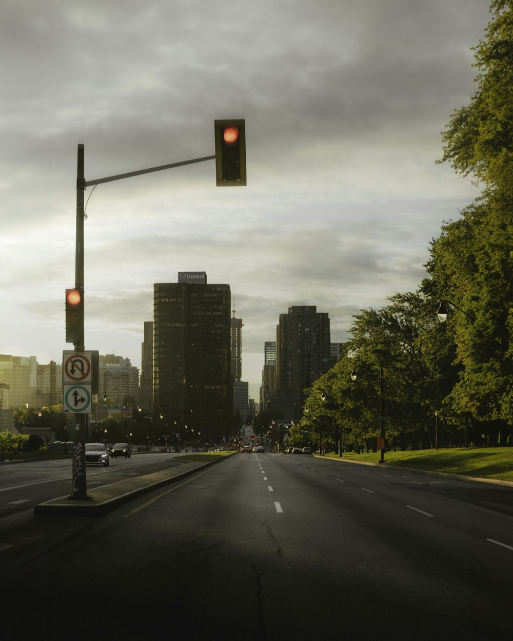 a traffic light on a street with tall buildings in the background