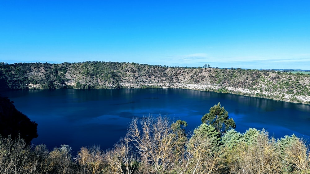 um lago azul cercado por árvores em um dia ensolarado