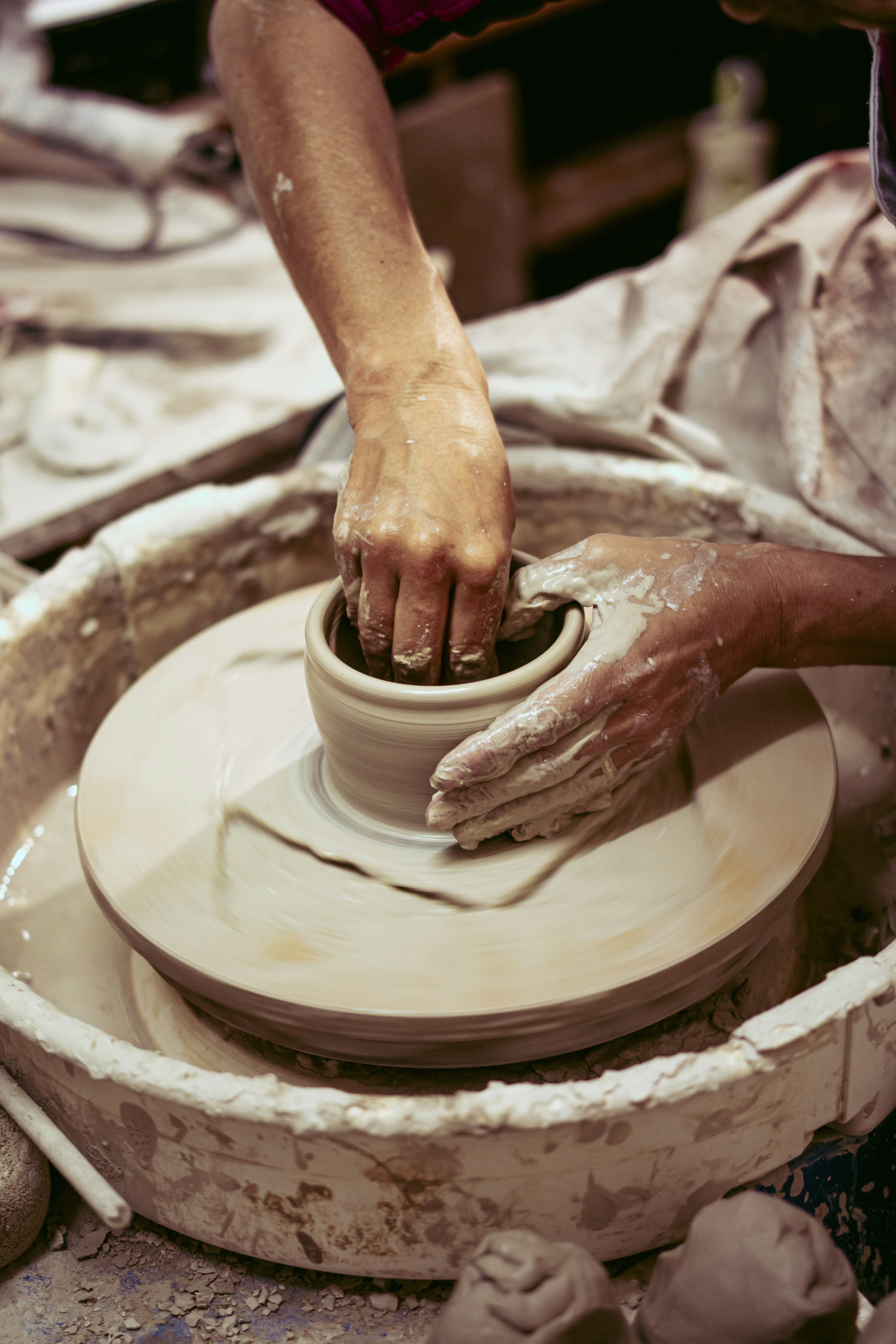 A person making a vase on a pottery wheel photo Free Pottery Image on