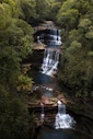 a large waterfall in the middle of a forest