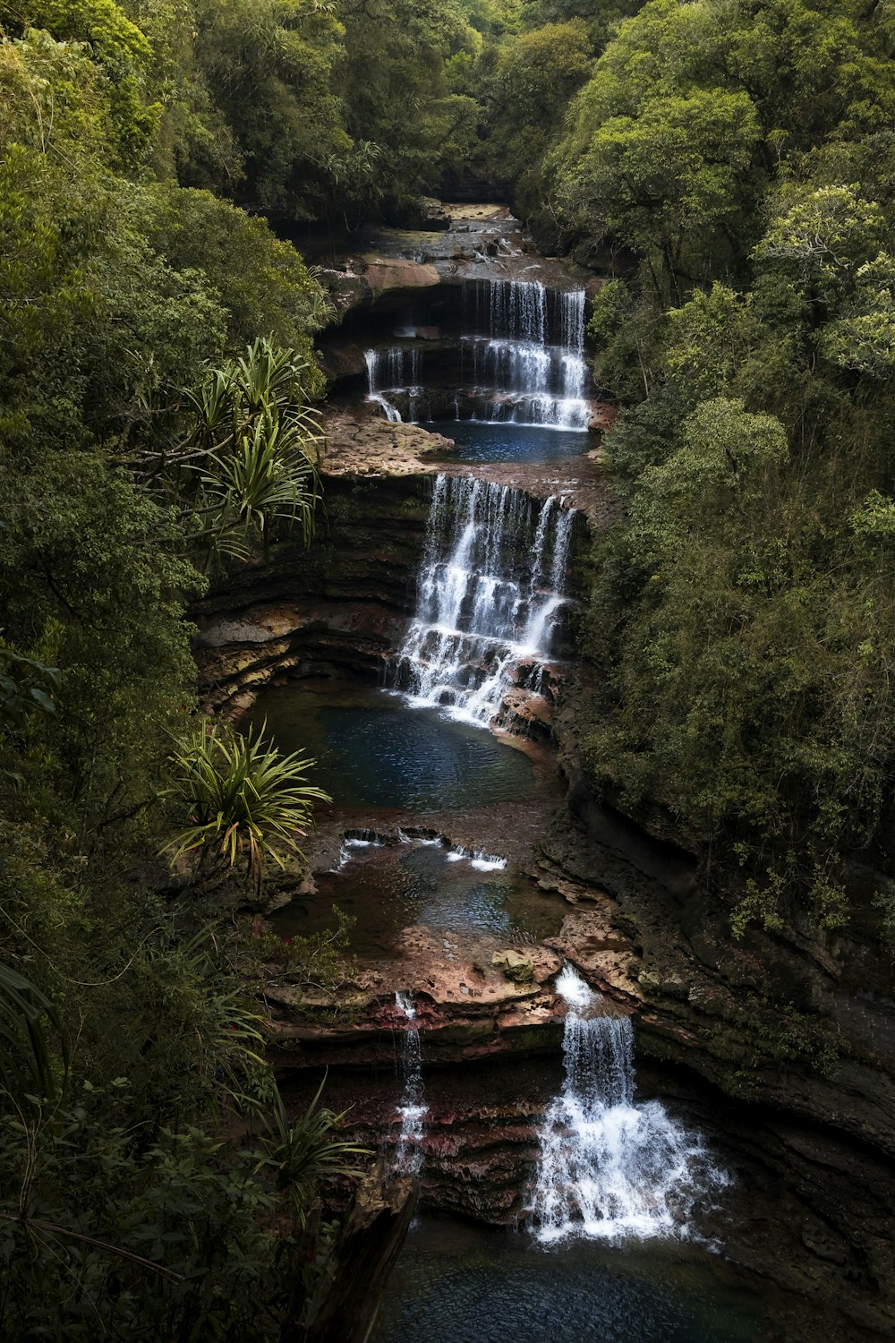 a large waterfall in the middle of a forest