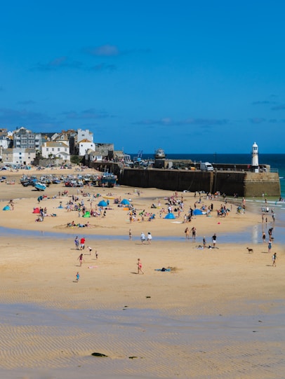 a group of people standing on top of a sandy beach