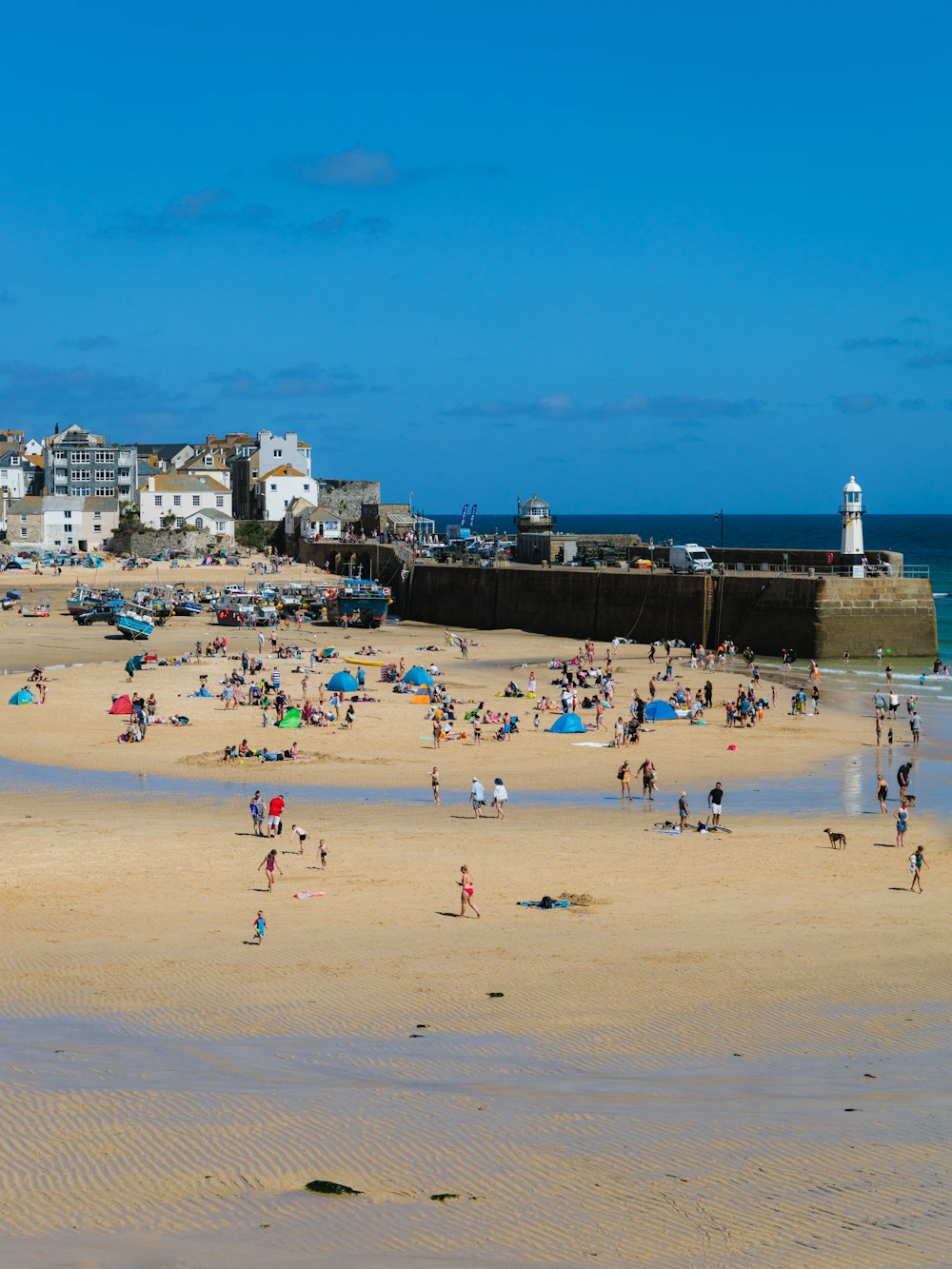 a group of people standing on top of a sandy beach