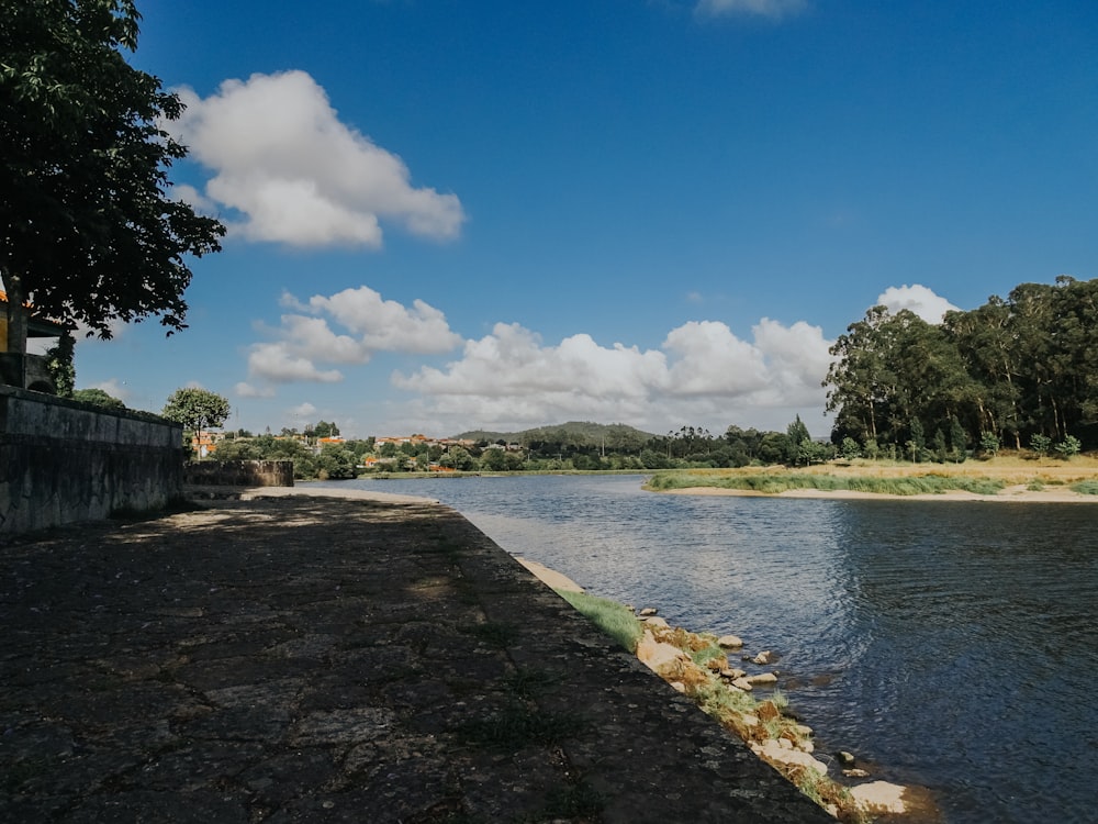 a body of water next to a dirt road