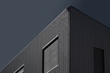 A sleek industrial factory exterior showcasing clean lines and minimalist design in deep charcoal tones.