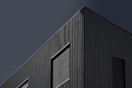 Exterior of a stylish commercial building in Pearland with sharp charcoal paint and clean lines.