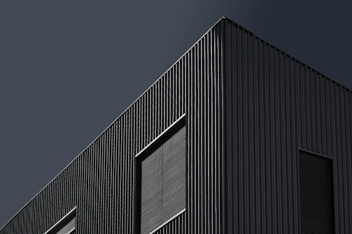 a black building with a clock on the side of it