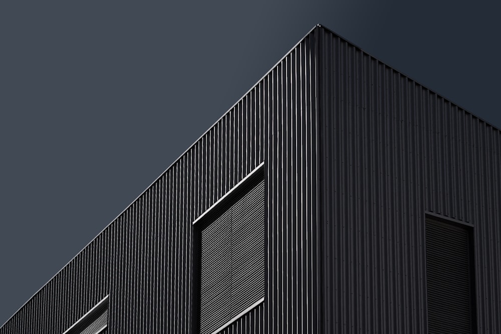Un edificio negro con un reloj en el costado