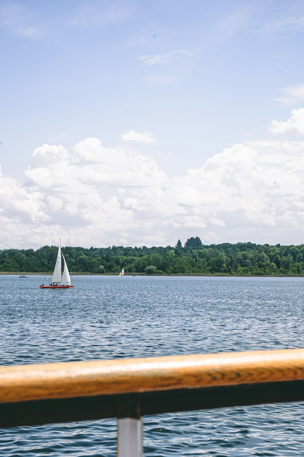 a sailboat on a lake with trees in the background