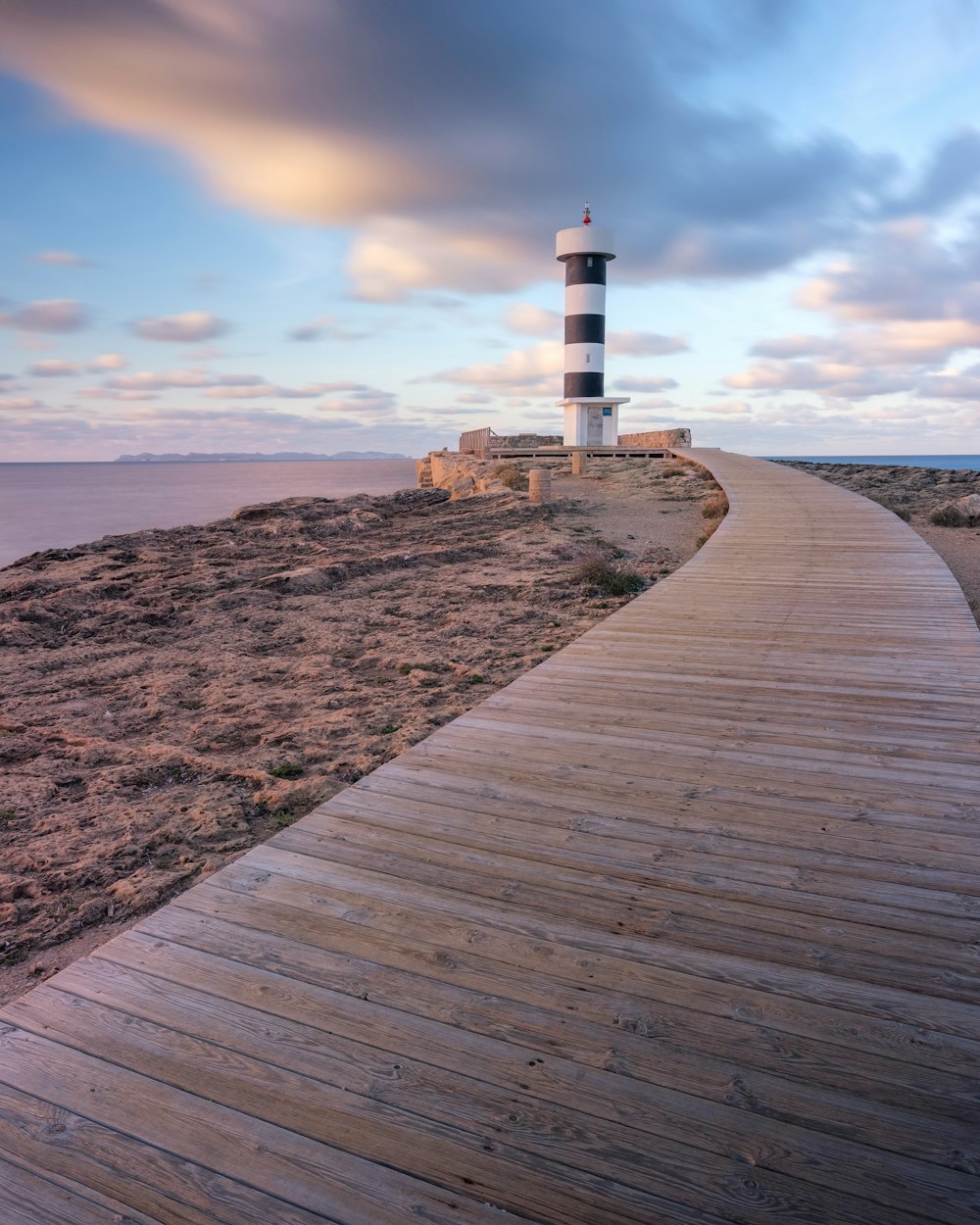 a wooden walkway leading to a light house