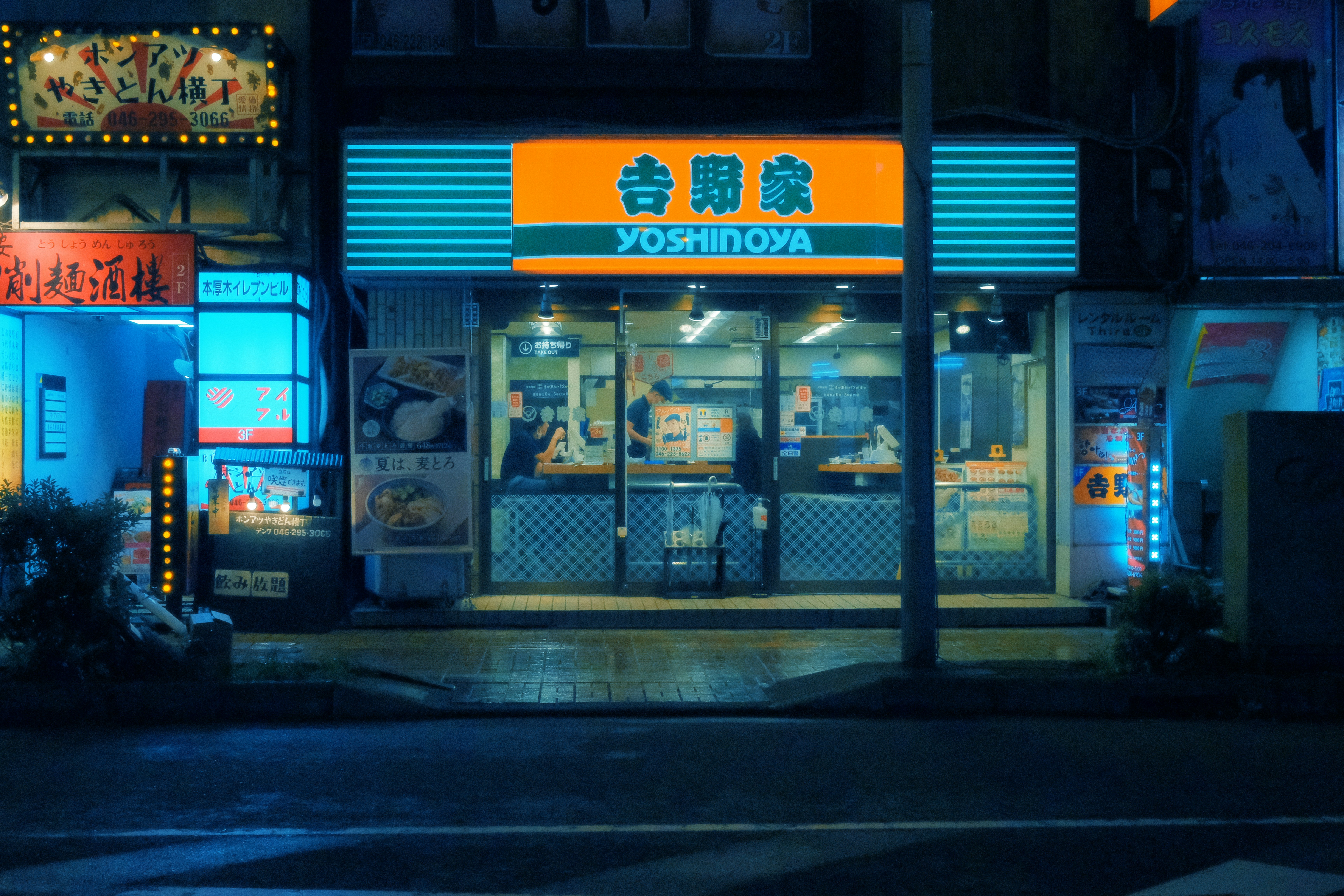 Interior of a Japanese fast food restaurant like Yoshinoya with customers eating breakfast