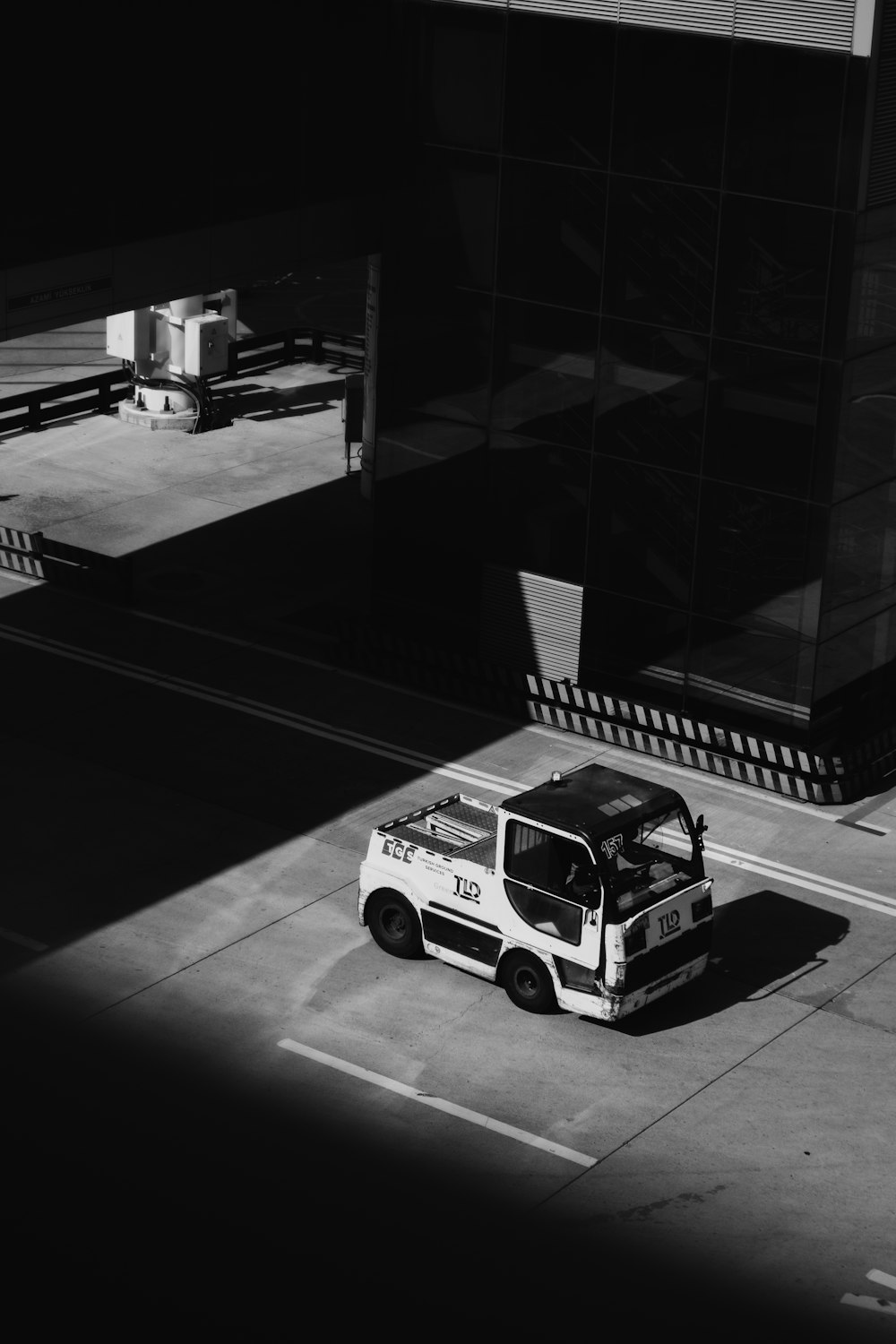 a black and white photo of a truck parked on the side of the road