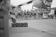 A group of runners starting a race under a large digital timer arch.