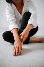 a woman sitting on the floor with her hands on her knees