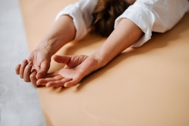 a woman laying on a bed with her hands on the edge of the bed