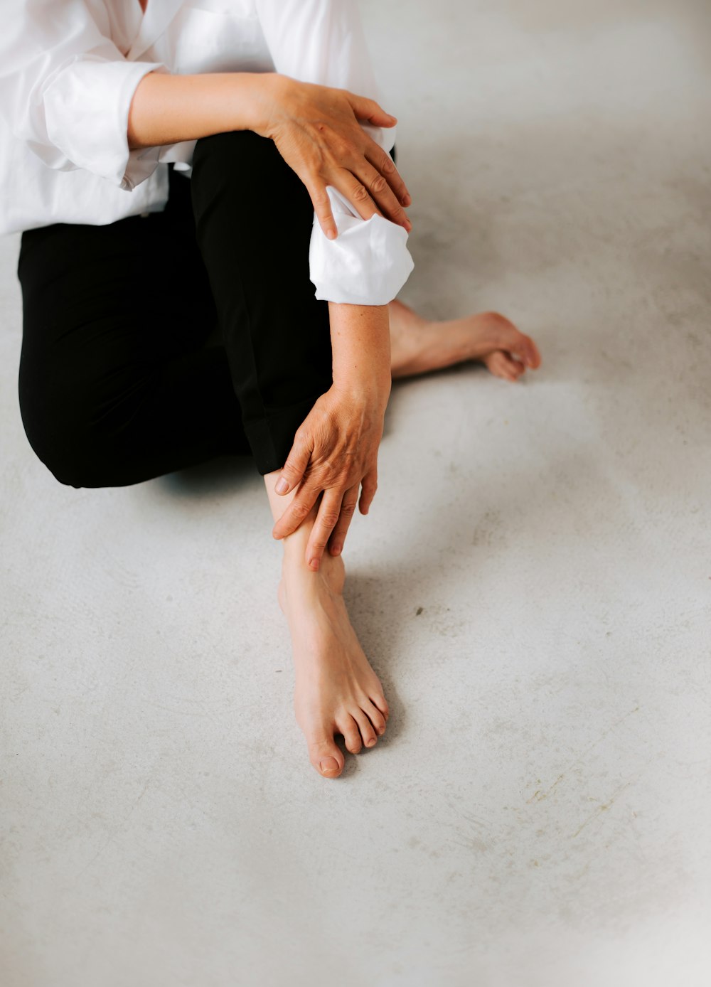 a woman sitting on the floor with her hands on her knees