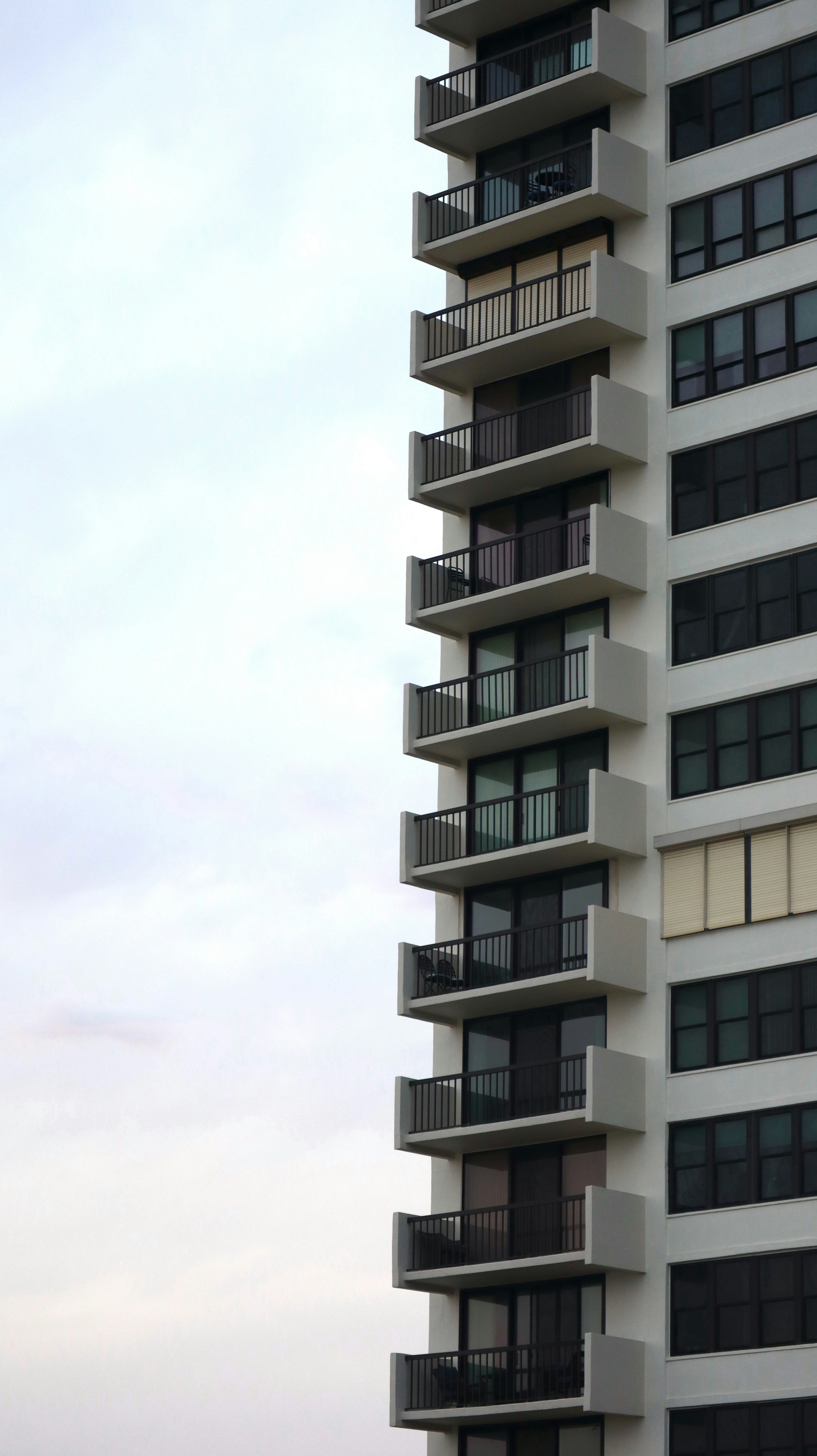 a tall white building with balconies and balconies