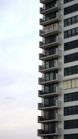 a tall white building with balconies and balconies