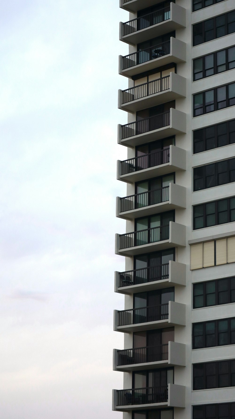 a tall white building with balconies and balconies