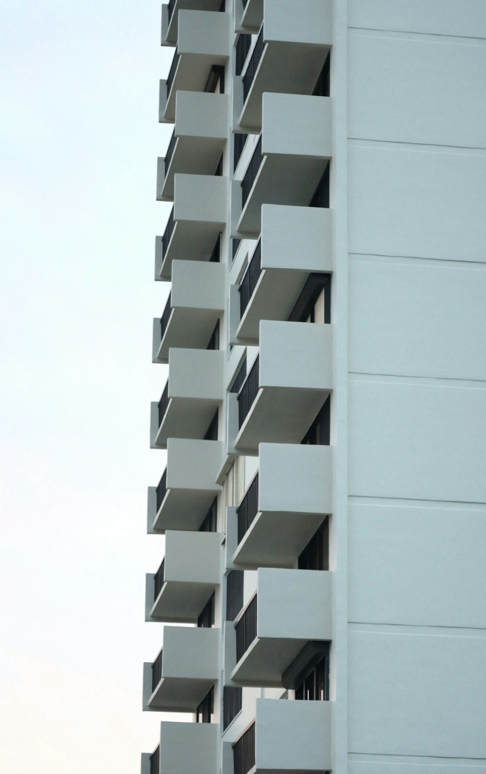 a tall white building with balconies and balconies