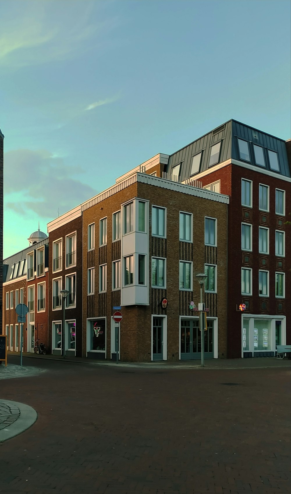 a street corner with a building and a clock tower in the background