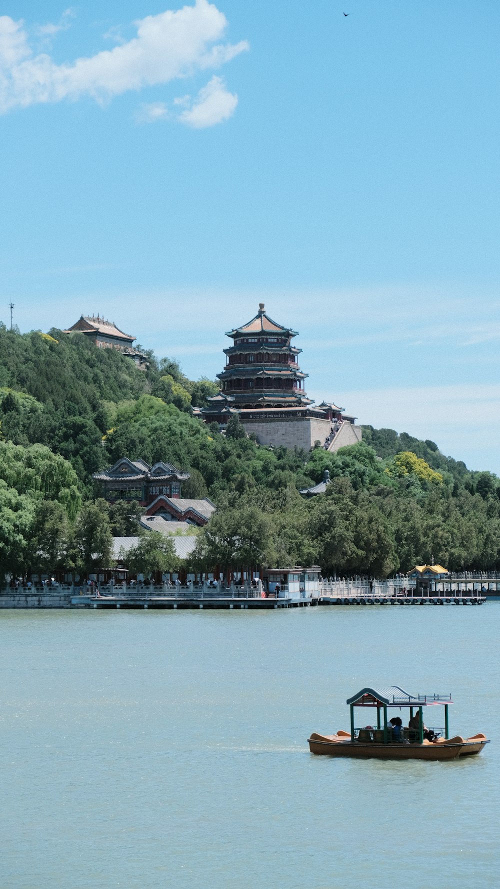 a boat floating on top of a lake next to a tall building