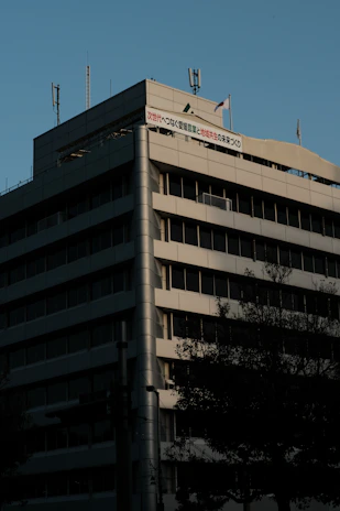 Image of a modern office building in Riyadh with the Saudi flag flying nearby.