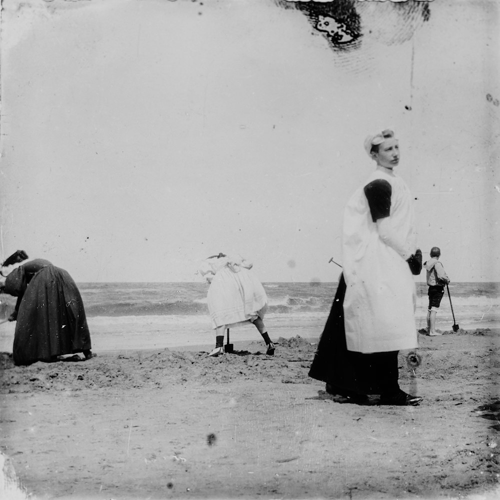 an old black and white photo of people on the beach