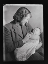 A warm and welcoming mom holding a baby surrounded by popular baby products.