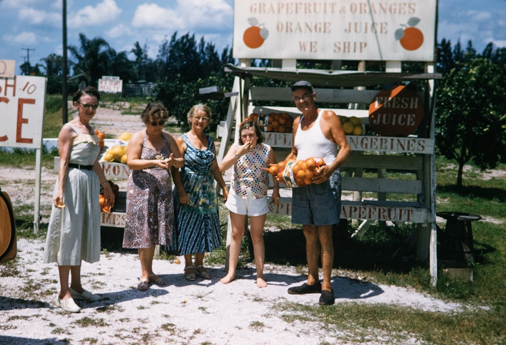 a group of people standing in front of a fruit stand