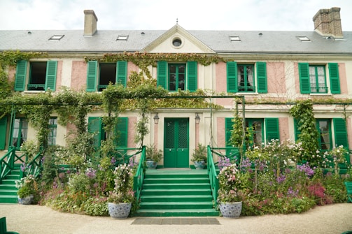 Exterior of a charming Wirral home with a newly painted façade in warm cream contrasting with deep green shutters.