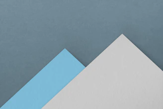 a blue and white piece of paper sitting on top of each other