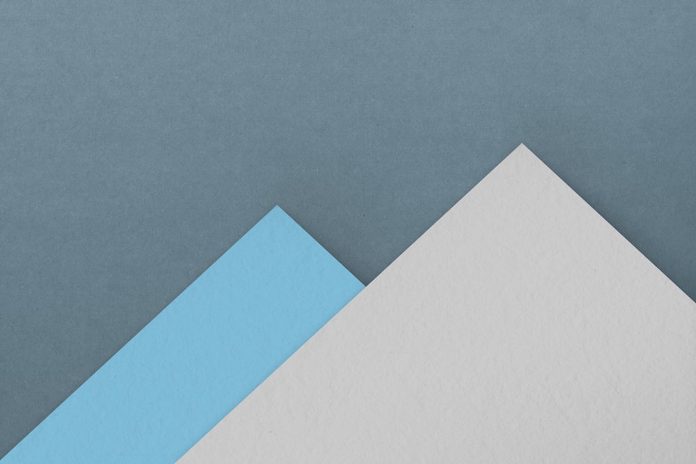 a blue and white piece of paper sitting on top of each other
