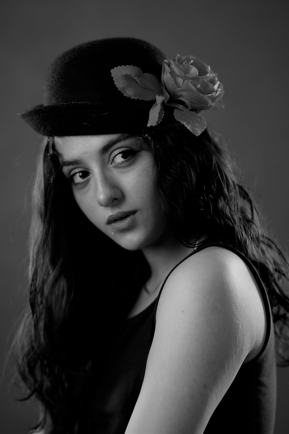 a woman wearing a hat with a rose on it
